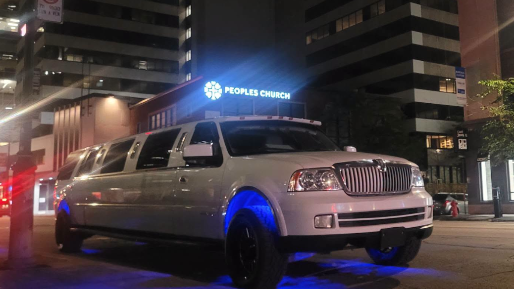 Limousine blanche illuminée la nuit en ville
